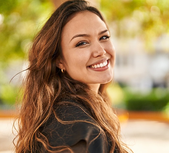 A beautiful woman smiling confidently in a park setting