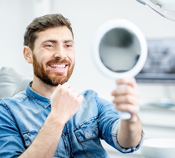 A dentist and hygienist chatting with a smiling patient